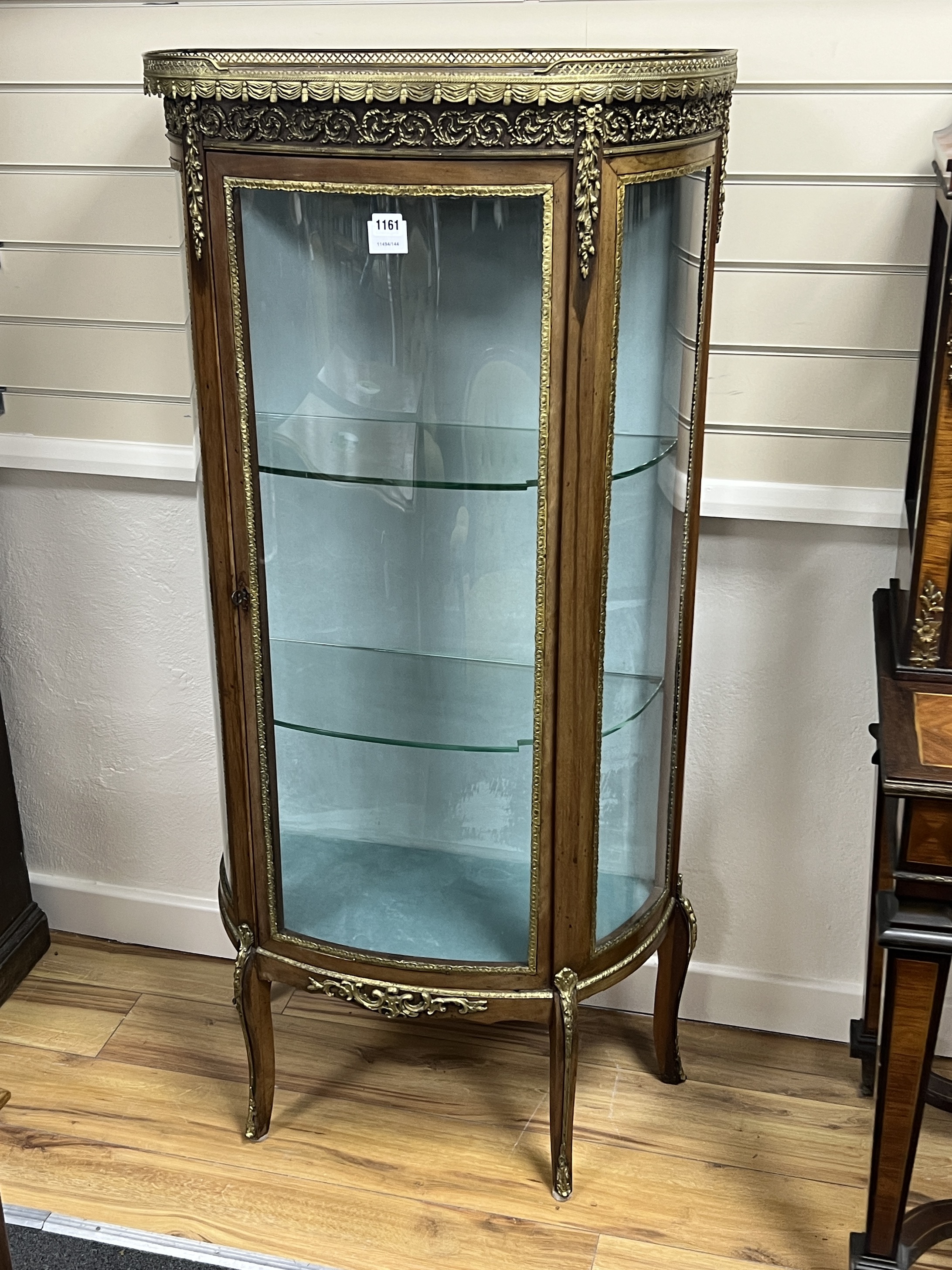 A French gilt metal mounted marble topped bow front vitrine, width 66cm, depth 32cm, height 140cm